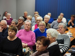 Seniorzy uczestniczący w debacie społecznej siedzą w sali konferencyjnej sulęcińskiej Komendy słuchając prowadzonych wykładów.