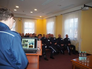 Komendant Powiatowy Policji w Sulęcinie podczas swojego wystąpienia podsumowującego wyniki pracy sulęcińskiej jednostki. Na drugim planie zaproszeni goście.