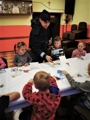 Dzielnicowy wraz z dziećmi podczas rozmowy o bezpieczeństwie.