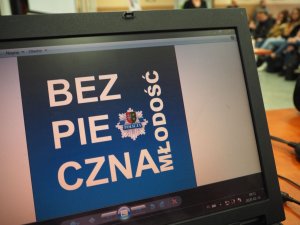 Ekran laptopa z wyświetlonym slajdem, z napisem Bezpieczna Młodość.