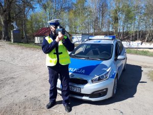 Policjant ruchu drogowego podczas wykonywania pomiaru prędkości.