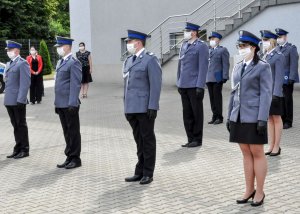 Policjanci stojący w pododdziale z zachowaniem odległości sanitarnych.