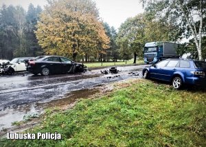 Osoby mazda i ford po zdarzeniu drogowym. Uszkodzone pojazdy stoją na drodze.