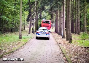 Radiowóz jedzie za autobusem przewożącym seniorów.