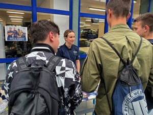 Policjantka rozmawia z odwiedzającymi stoisko promocyjne jednostki.