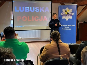 Policjantka prowadzi spotkanie promocyjne dla uczestników giełdy pracy. Na ekranie obok niej wyświetlany jest napis Lubuska Policja.