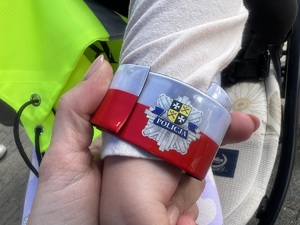 Odblaskowa opaska z logo sulęcińskiej Policji na rączce dziecka.