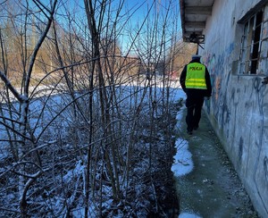 Policjant sprawdza zewnętrzną część przynależącą do pustostanu.