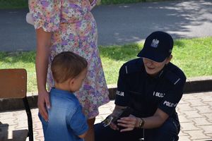 Policjantka wręcza chłopcu odblask.