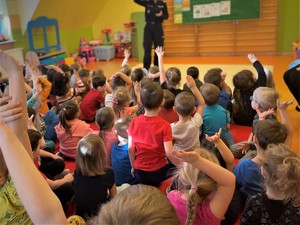 Policjantka prowadzi spotkanie edukacyjne dla dzieci.