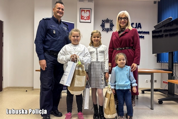 I Zastępca Komendanta Powiatowego Policji w Sulęcinie z laureatkami konkursu plastycznego oraz opiekunem.