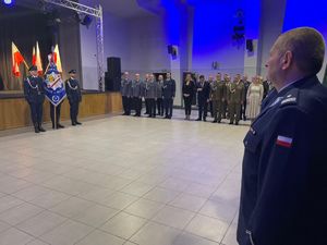 Pełniący obowiązki Komendant Powiatowy Policji w Sulęcinie podinspektor Krzysztof Staszewski na tle pocztu sztandarowego oraz zaproszonych gości.