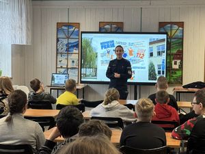 Policjantka prowadzi spotkanie edukacyjne w świetlicy szkolnej na temat zimowego bezpieczeństwa.