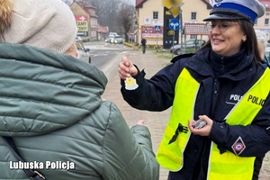 Policjantka wręcza odblask seniorce.