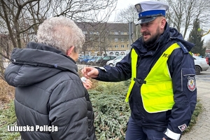 Policjant wręcza odblask seniorce.