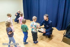 Policjanci rozdają odblaski przedszkolakom.