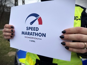 Policjantka trzyma w dłoniach logo działań ROADPOL.