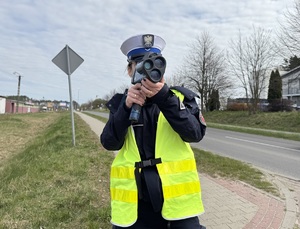 Policjantka mierzy prędkość miernikiem.