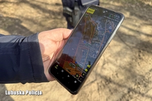 Policjant korzysta na telefonie z aplikacji do poszukiwania osób Siron.