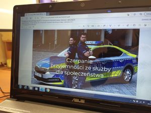 Ekran laptopa w wyświetloną prezentacją promującą zawód policjanta.