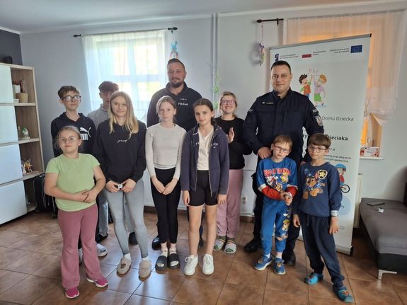 Policjanci pozują do zdjęcia z młodzieżą.