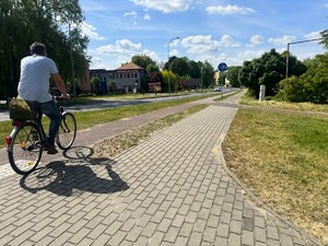 Mężczyzna jedzie rowerem po ścieżce rowerowej.