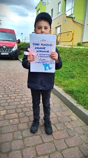 Chłopiec trzyma w dłoniach malunek.