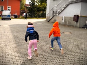 Dzieci biegną po placu komendy.