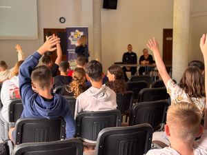 Policjantka prowadzi debatę społeczną dla młodzieży.