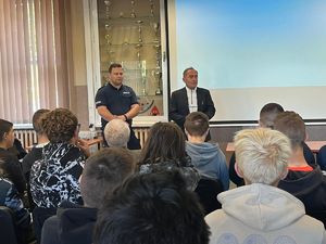 Policjant i dyrektor szkoły podczas spotkania profilaktycznego.