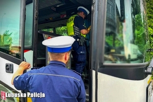 Policjanci sprawdzają dokumenty kierowcy autokaru.