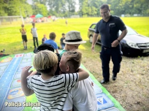 Dzieci grają z wielkoformatową grę Bezpieczni na drodze z Policją.