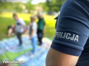 Dzieci grają z wielkoformatową grę Bezpieczni na drodze z Policją pod nadzorem funkcjonariusza.