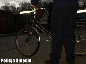 Mężczyzna stoi przy rowerze.