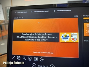 Ekran laptopa z włączonym slajdem na temat debaty o handlu ludźmi.