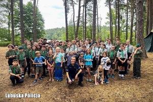 Policjantka pozuje do wspólnego zdjęcia z uczestnikami obozu harcerskiego.