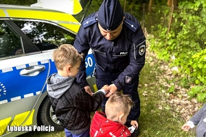 Policjant zakłada dzieciom odblaski.