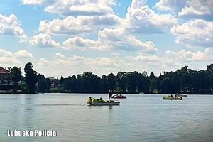 Osoby wypoczywające nad jeziorem.