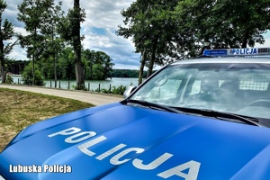 Radiowóz na tle jeziora.