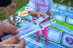 Policjant wręcza odblask dziewczynce.