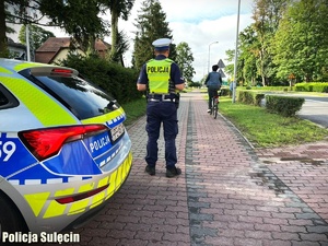 Policjanci obserwują przejeżdżających rowerzystów.
