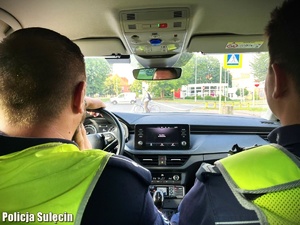 Policjanci w radiowozie obserwują ruch.