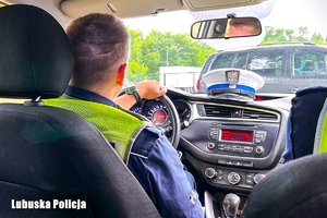 Policjanci wewnątrz radiowozu obserwują ruch kołowy.