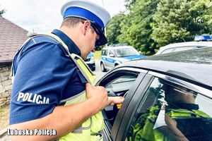Policjant kontroluje trzeźwość kierowcy.