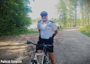 Policjant na rowerze nad jeziorem.