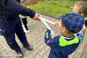 Policjant rozdaje dzieciom odblaski.