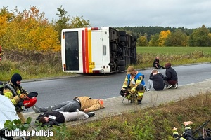 wywrócony autobus, policjanci i strażacy podczas akcji ratowniczej
